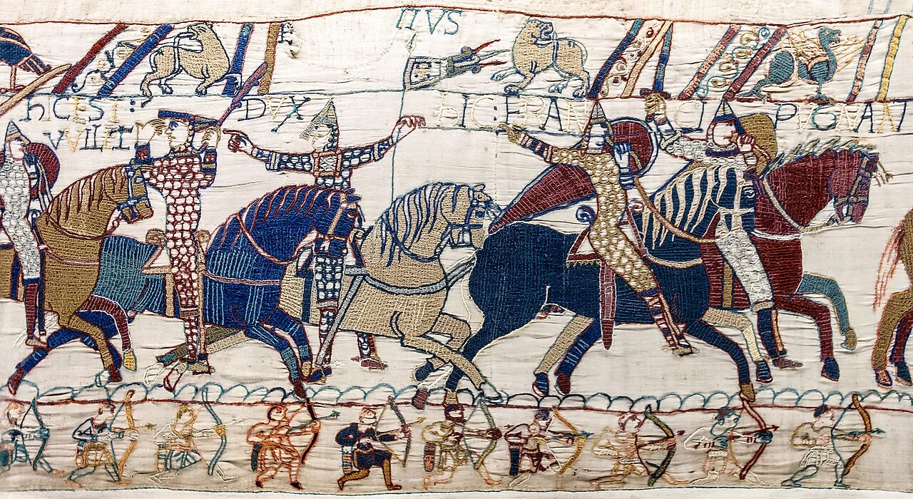 Au plus fort de la bataille d’Hastings, Guillaume relève son casque pour montrer qu’il est vivant, tandis qu’Eustache de Boulogne le désigne du doigt (Tapisserie de Bayeux, scène 55).